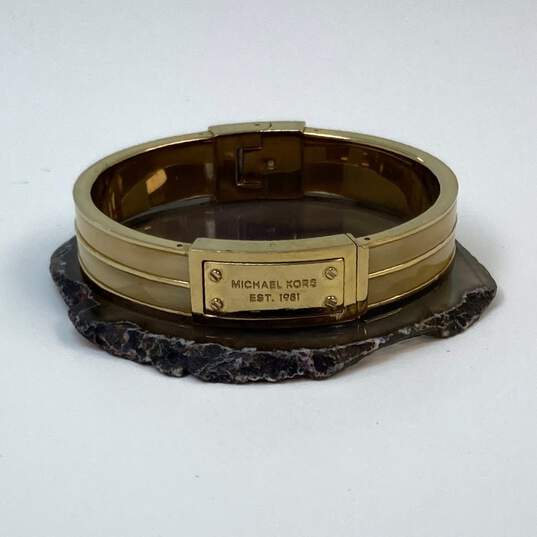 Designer Michael Kors Gold Tone Heritage Logo Hinged Bangle Bracelet image number 1